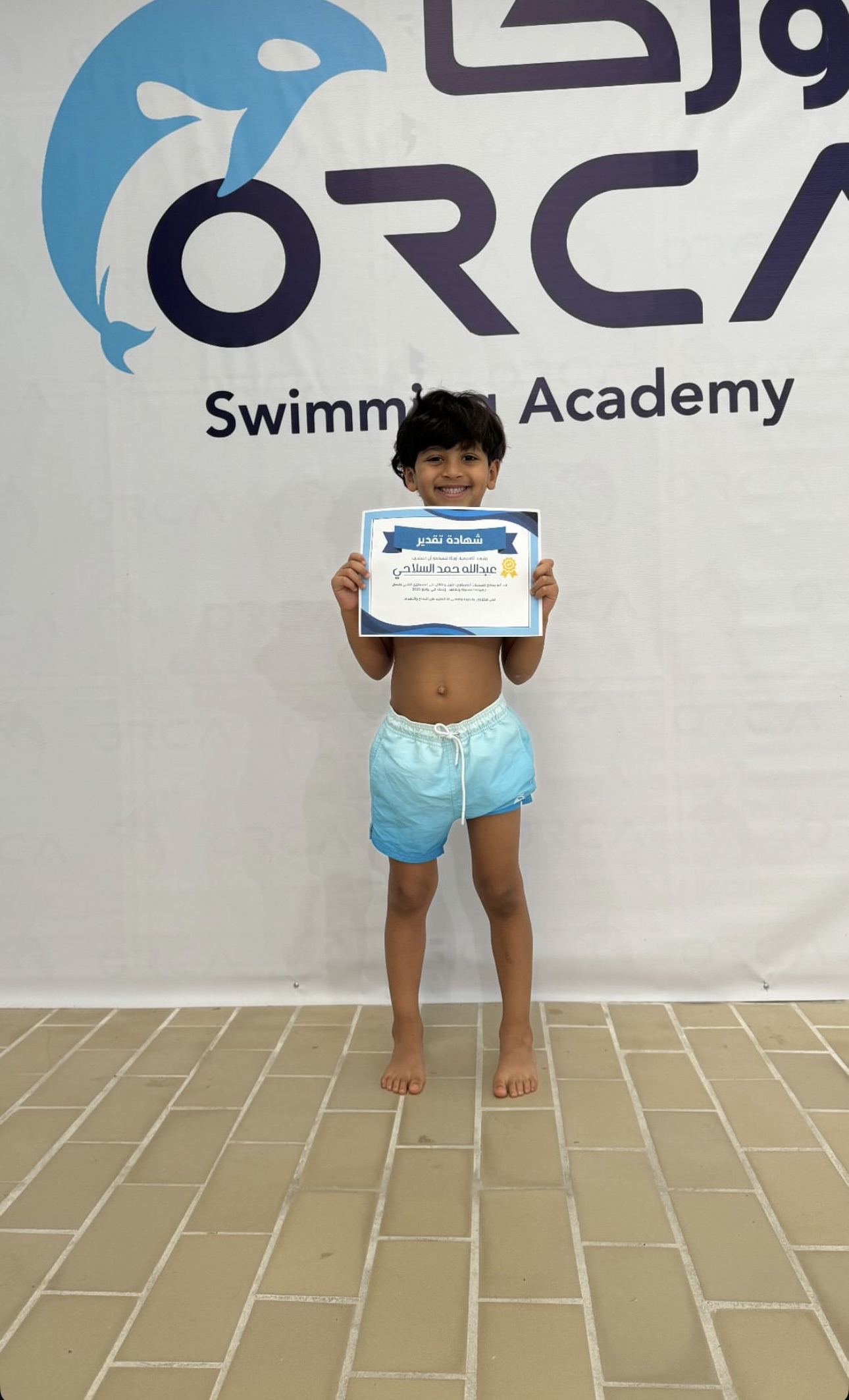 Orca Swimming Academy student with certificate